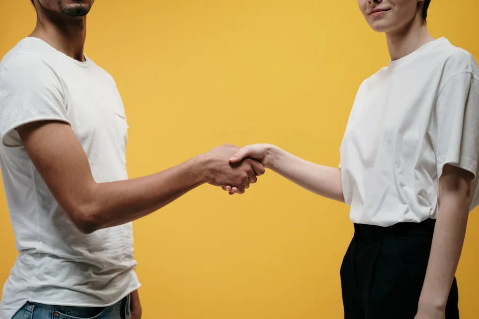 Two people shaking hands symbolizing agreement and partnership.