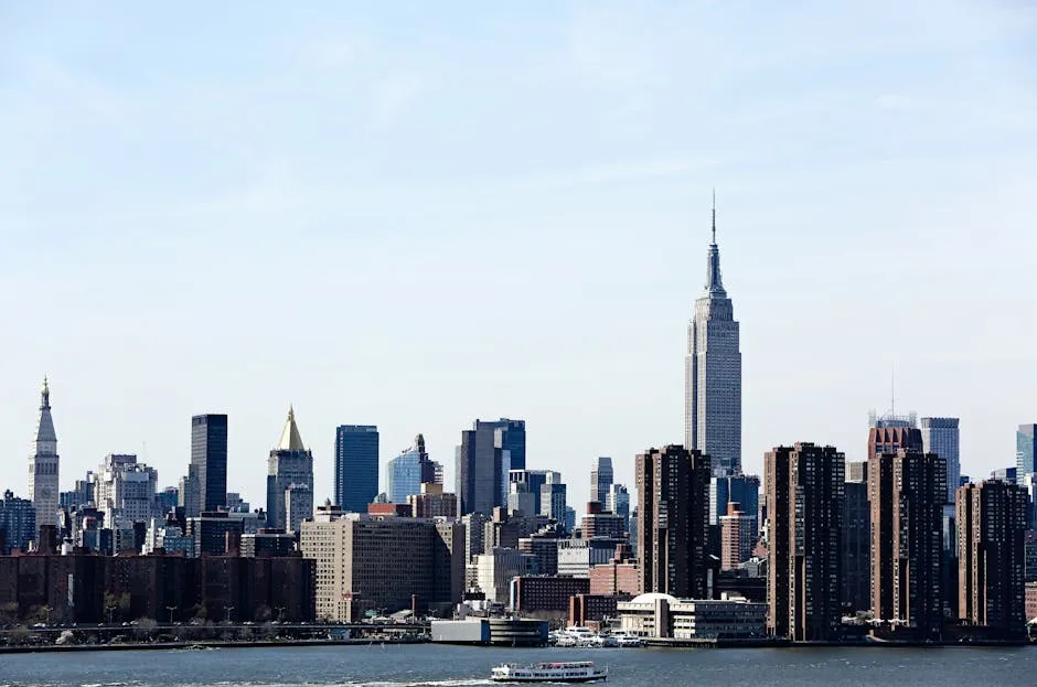 A stunning view of the New York City skyline featuring the iconic Empire State Building under a clear blue sky.