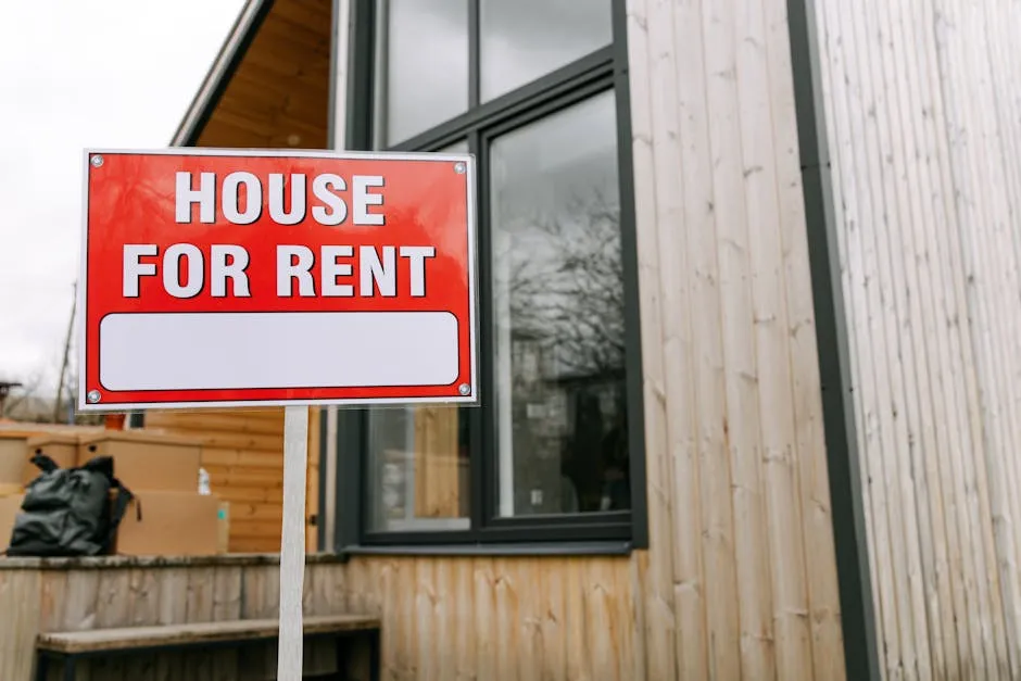 Red 'House for Rent' sign outside modern wooden house.