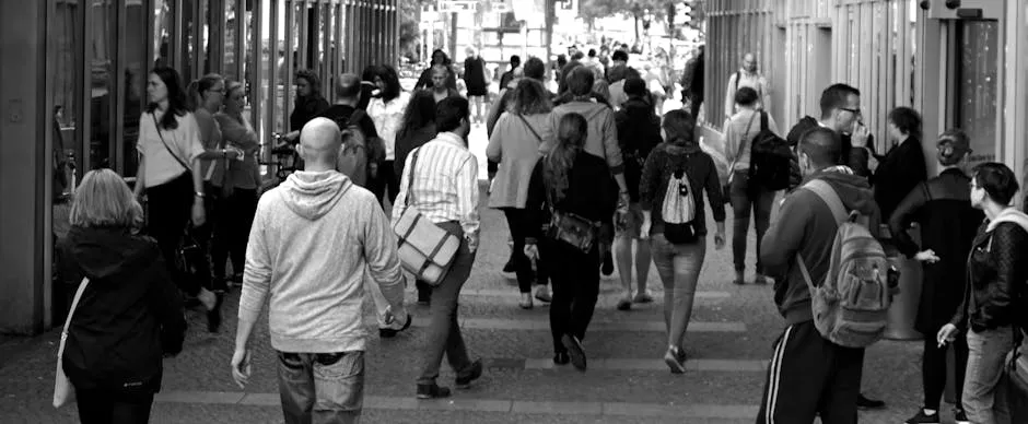 A bustling street scene capturing diverse pedestrians walking outdoors in an urban setting.