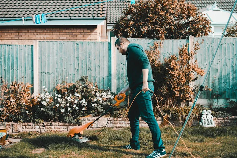 A man using an electric mower in a garden on a sunny day, capturing outdoor chores and gardening vibes.