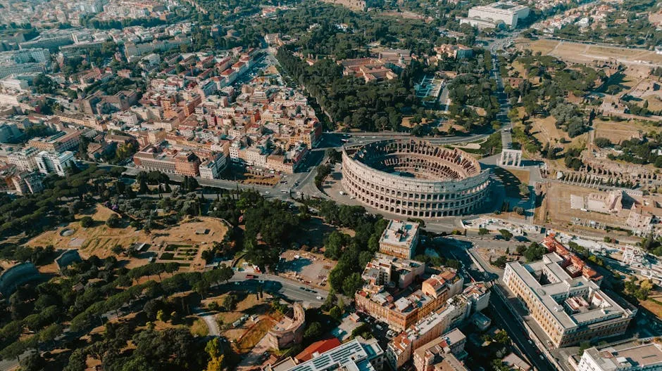 Stunning aerial view of the iconic Colosseum surrounded by the vibrant cityscape of Rome, Italy.