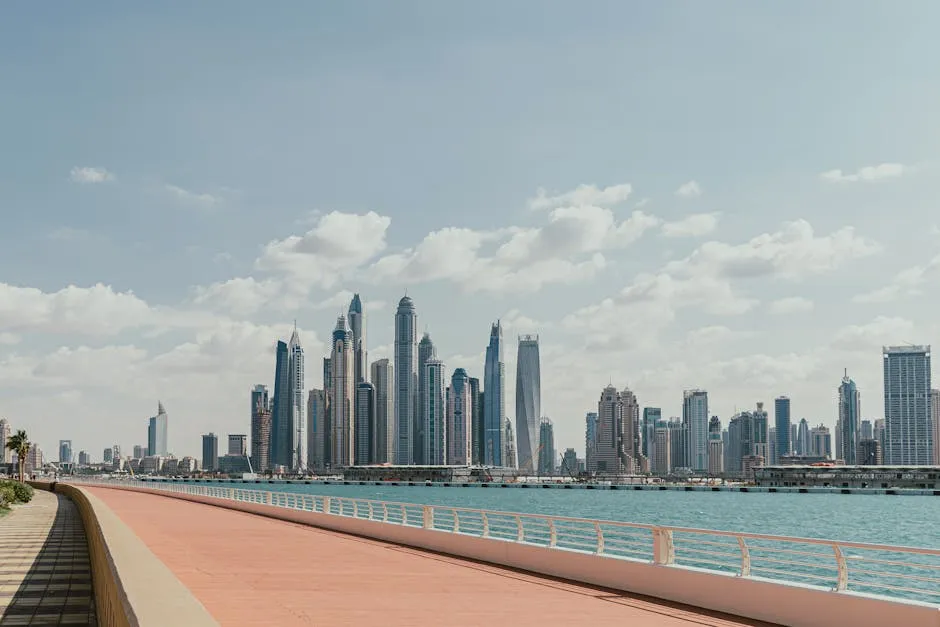 Beautiful view of Dubai Marina's skyscrapers along a sunny waterfront promenade.