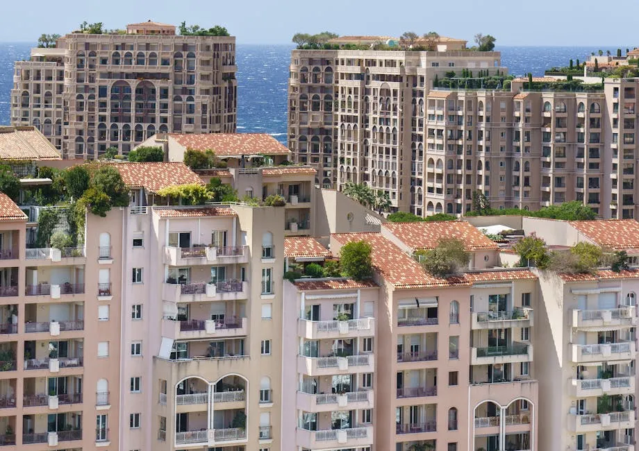 Panoramic view of luxury Mediterranean-style apartments in Monaco, with a backdrop of the blue sea.