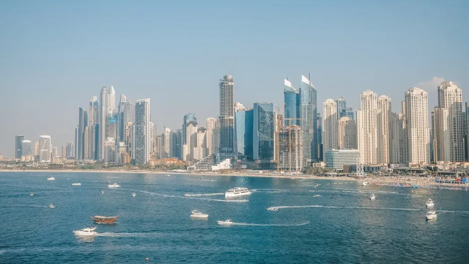 Scenic view of Dubai Marina skyline with iconic skyscrapers and boats in the harbor.